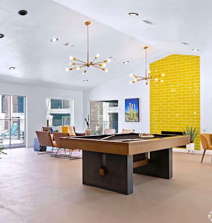 a living room with a pool table and a dining room in the background