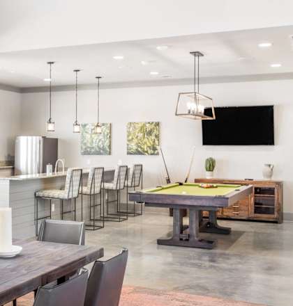 a large living room with a pool table and a dining room