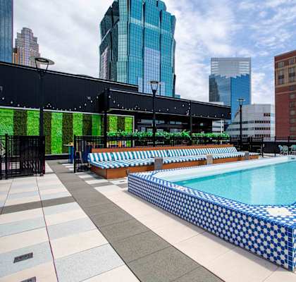 a pool on the rooftop of a building with skyscrapers