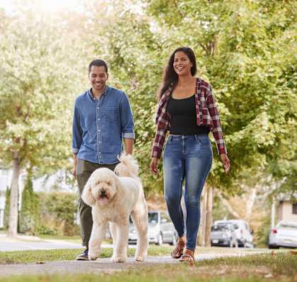 People walking a dog in a neighborhood  at Old Green Place  Apartments, Integrity Realty LLC, Beachwood, Ohio