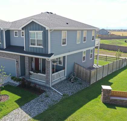 a blue house with a porch and a yard