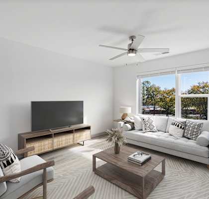 A modern living room with a television, sofa, and a wooden coffee table.