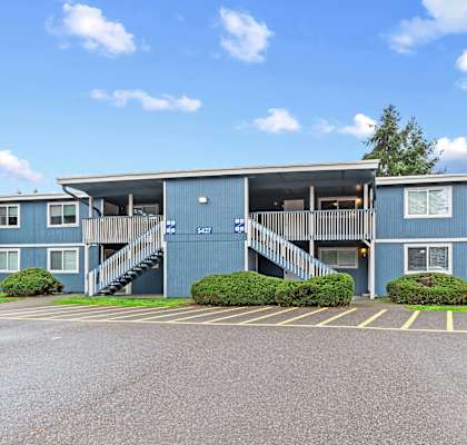 A blue building with a parking lot in front.