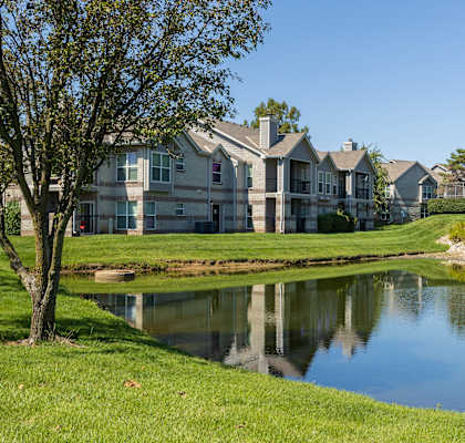 The exterior of Hawthorne Apartment Homes features a well-kept building with lush landscaping.