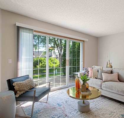 a living room with a couch and a sliding glass door to a patio at Seasons Villas, Woodbury, MN 55125
