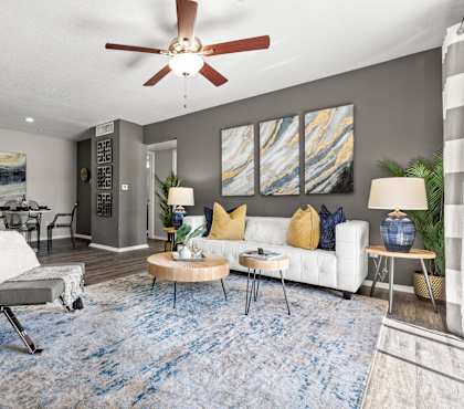 A modern living room with a grey chair and a blue rug.