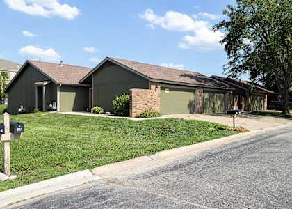 A house with a grey roof and a green lawn.