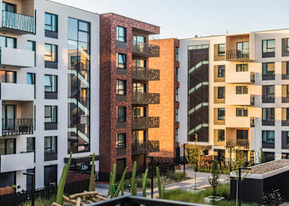 A row of modern apartment buildings with balconies and windows.