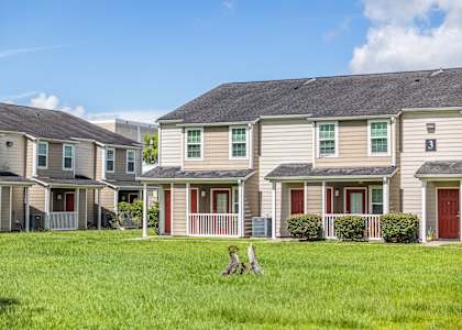 A row of houses with a green lawn in front.