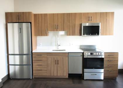 A modern kitchen with wooden cabinets and stainless steel appliances.