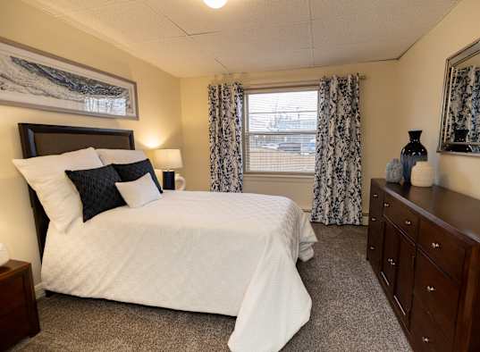 A bedroom with a large bed and a dresser.