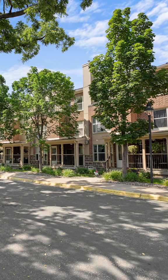 a street view of an apartment building with trees