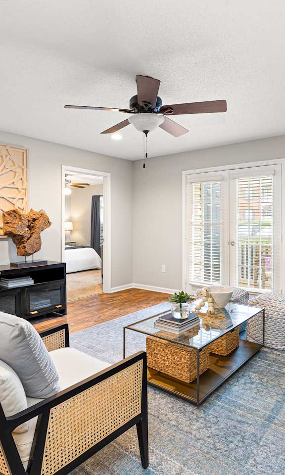 A living room with a ceiling fan and a blue couch.