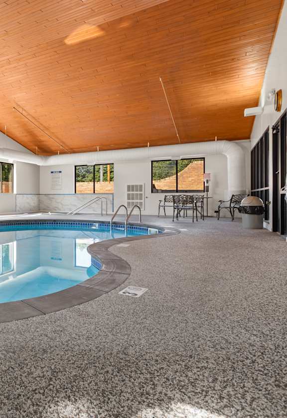 A large indoor swimming pool with a wooden ceiling.