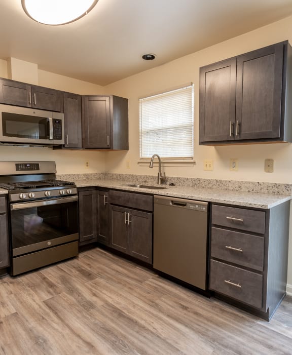 a kitchen with dark wood cabinets and stainless steel appliances at Carlson Woods Townhomes, Baltimore, MD, 21244