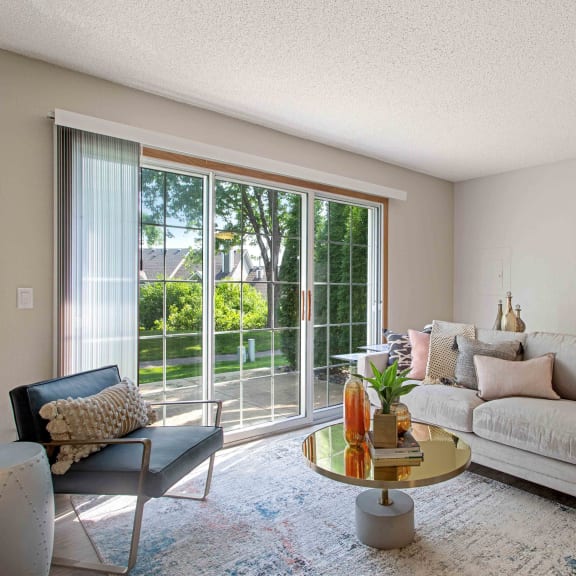 a living room with a couch and a sliding glass door to a patio at Seasons Villas, Woodbury