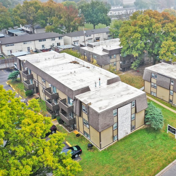 an aerial view of a row of apartment buildings with gray roofs