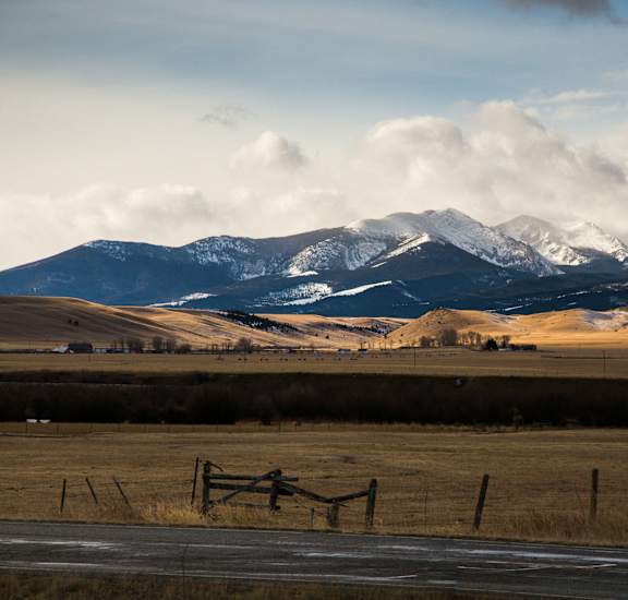 a view of a field with mountains in the background