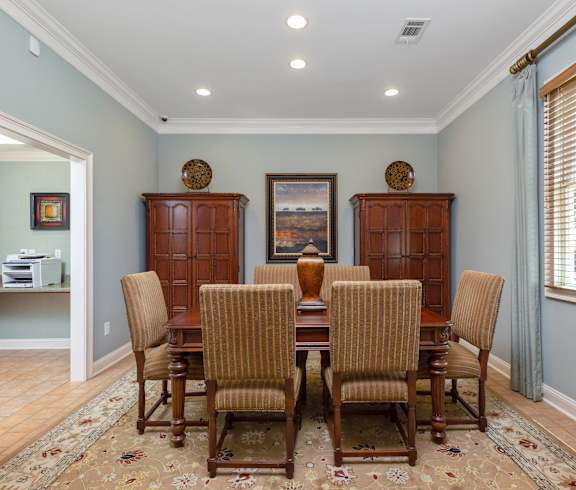 a dining room with a wooden table and chairs at Bedford Parke Apartments in Warner Robins, Georgia 31088