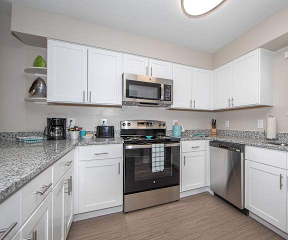 a kitchen with white cabinets and granite countertops