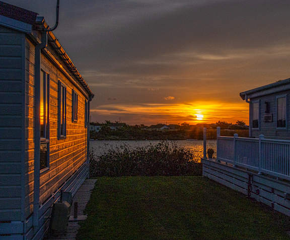 A sunset view from a house with a deck.