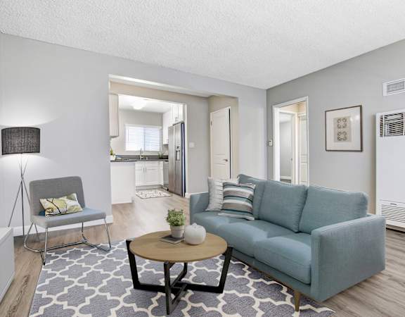 A living room with a grey couch, a white chair, and a coffee table.