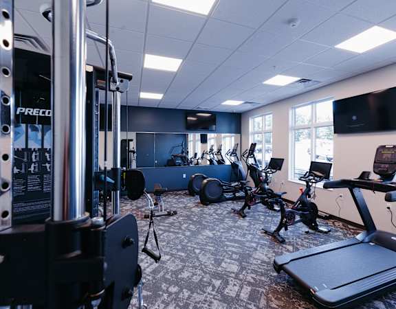 a gym with various exercise machines and a tv