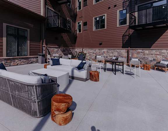 a covered patio with couches and tables on a patio