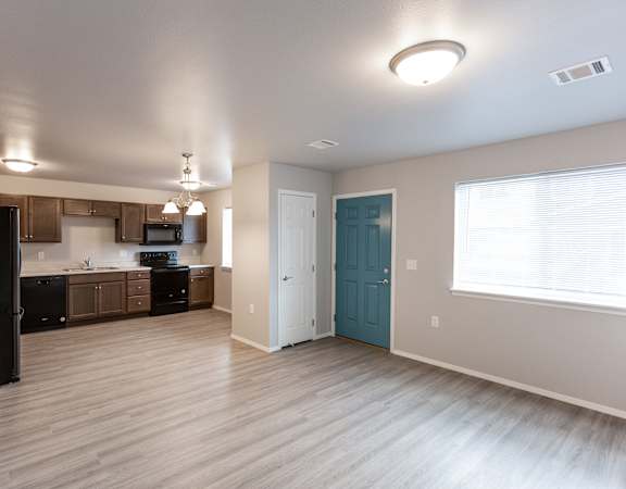 A kitchen with wooden floors and a blue door.