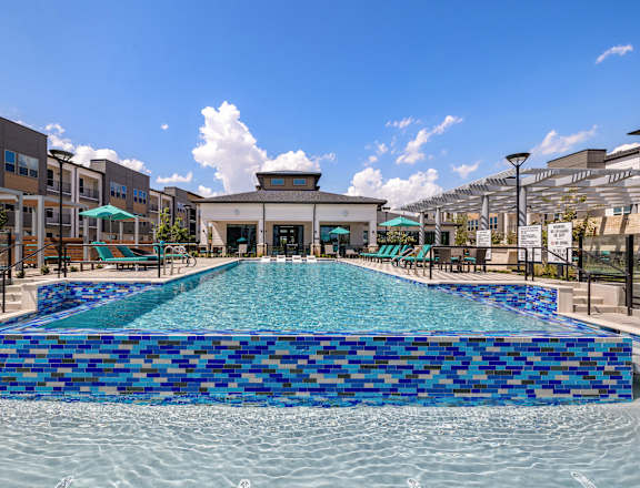 A large blue tiled pool in the middle of a building complex.