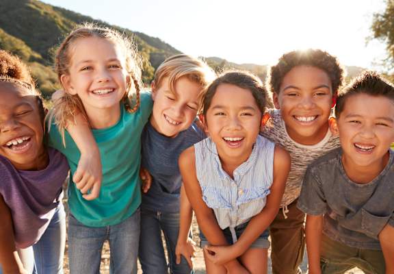 A group of children are standing together outside.