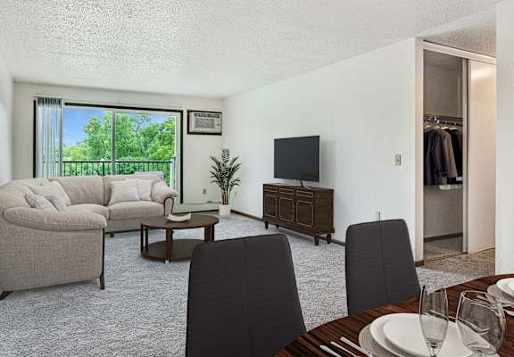 a living room and dining room with a couch and a tv