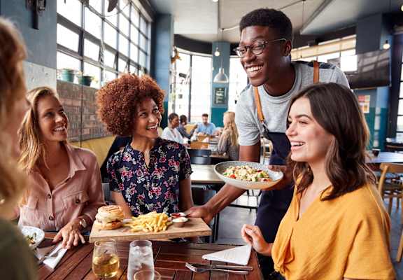 a group of people sitting around a table eating food at a restaurant at Oakridge Apartments, Antioch, California