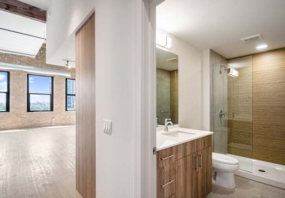 A bathroom with a toilet, sink, and a window.