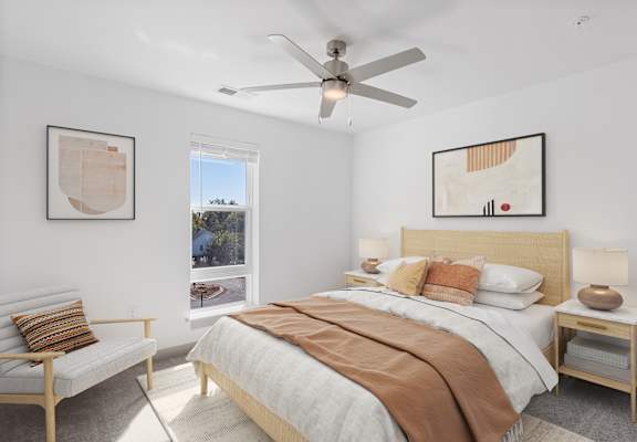 A bedroom with a large bed and a ceiling fan.
