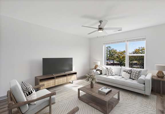 A modern living room with a television, sofa, and a wooden coffee table.