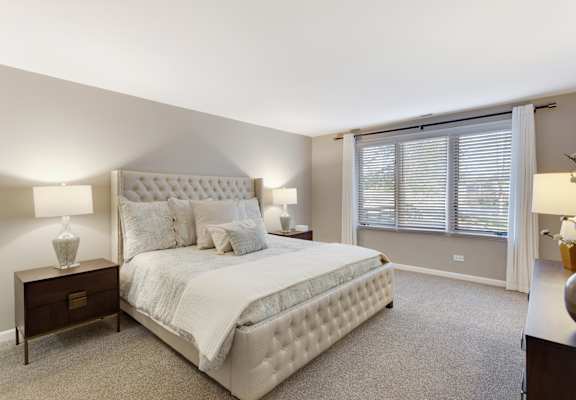 A cozy apartment bedroom showcasing contemporary furnishings and natural light.