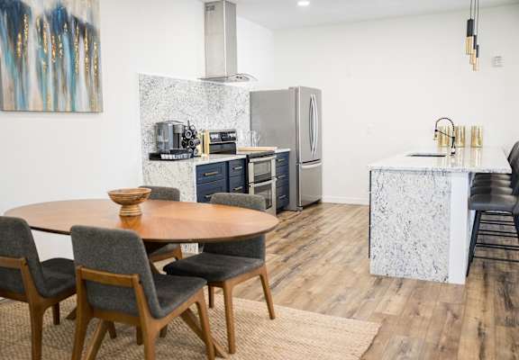 A modern kitchen with a dining table and chairs.
