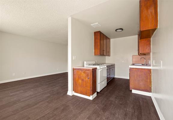 A kitchen with white appliances and wooden cabinets.