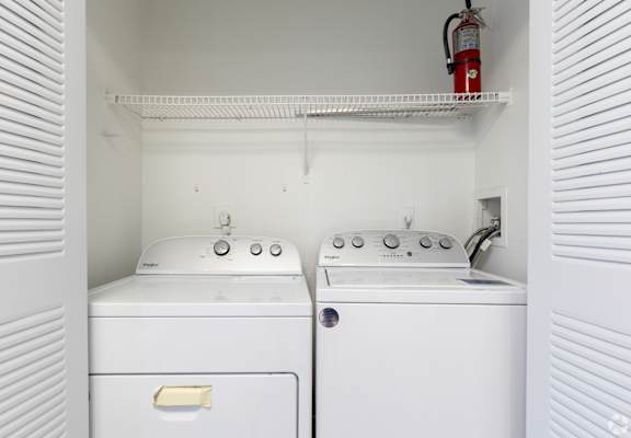 an empty laundry room with two washes and a dryer