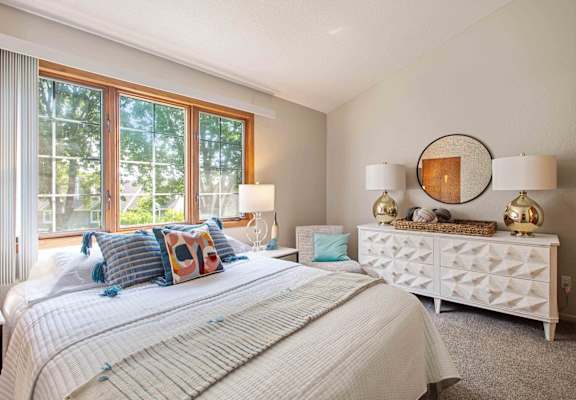a bedroom with a bed and a large window at Seasons Villas, Woodbury, 55125