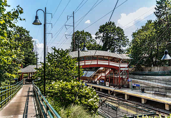 A train station with a red roof and a green railing.