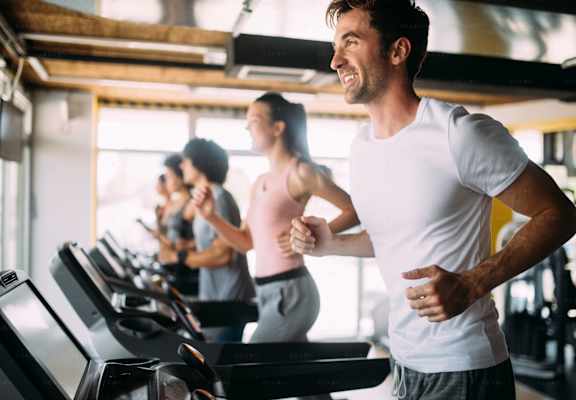 a group of people running on a treadmill in a gym