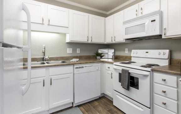 a kitchen with white appliances and white cabinets at Abbington Place Apartments, Greensboro , 27407