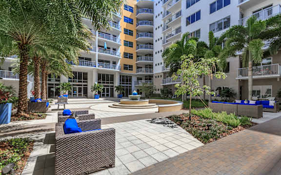a person sitting on a bench in front of an apartment building
