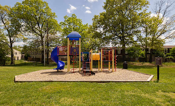 a playground with a blue slide and monkey bars at The Orchards at Severn Townhomes*, Severn
