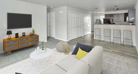 A living room with a white couch and a television on the wall.