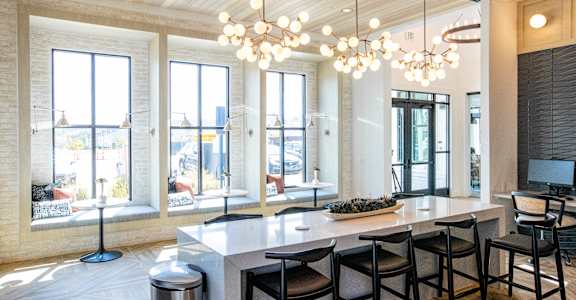 a dining room with a large table and chairs and windows
