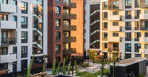 A row of modern apartment buildings with balconies and windows.