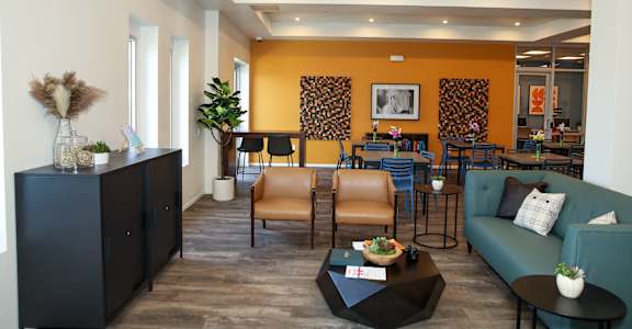 the lobby of a hotel with a blue couch and chairs and a table and chairs